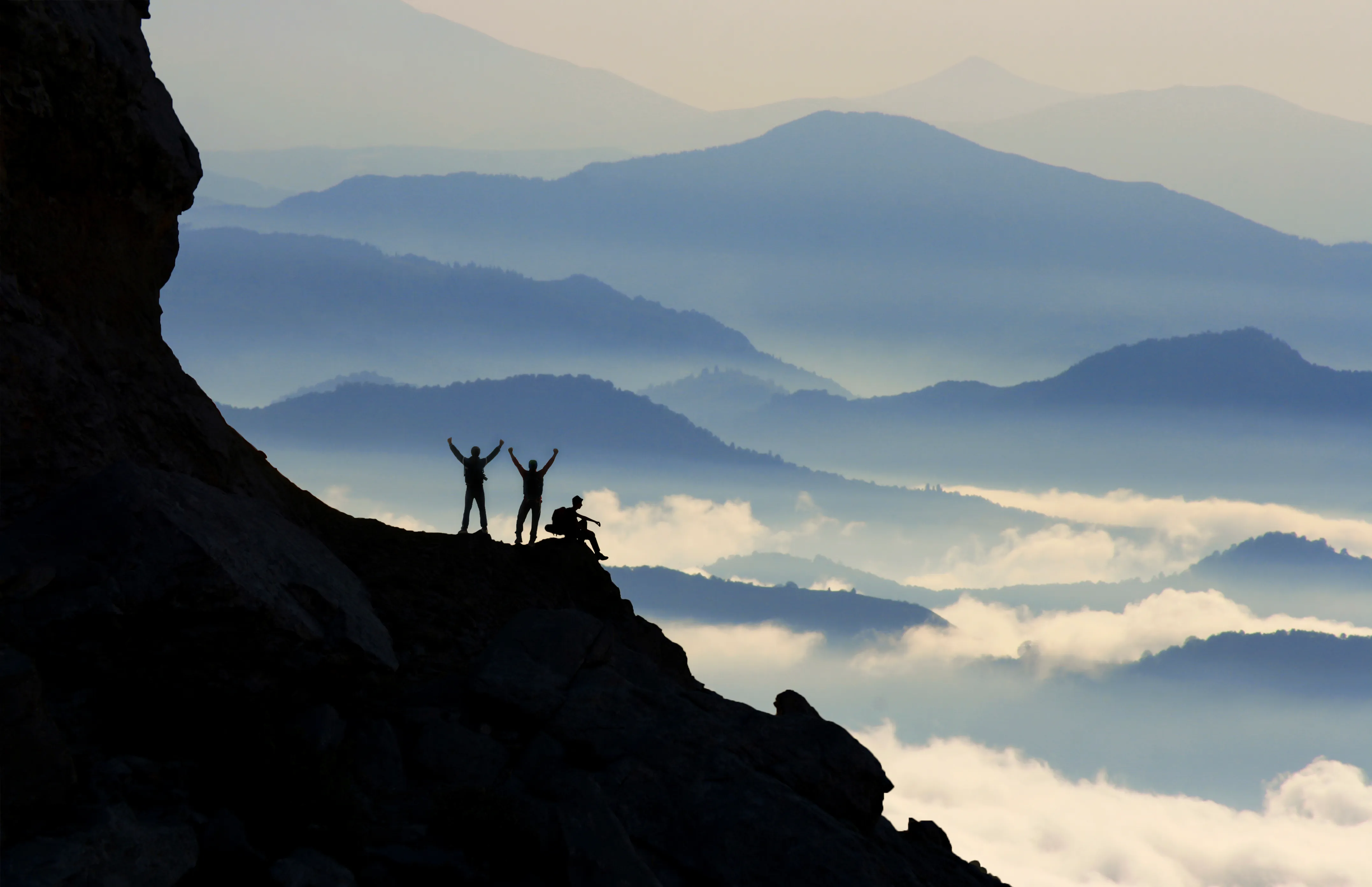 successful people at the summit of foggy mountains